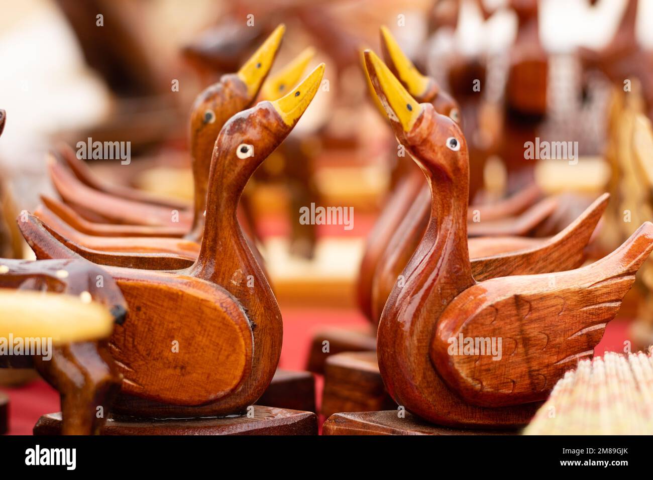 Selektiver Fokus auf die Anzahl handgefertigter Holzenten zum Verkauf auf dem Markt Stockfoto