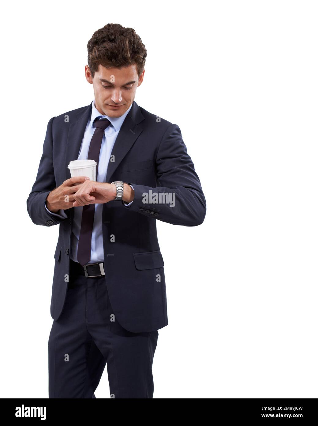 Gerade rechtzeitig für das Treffen. Ein gutaussehender junger Geschäftsmann, der auf seine Uhr schaut, während er eine Tasse Kaffee hält. Stockfoto