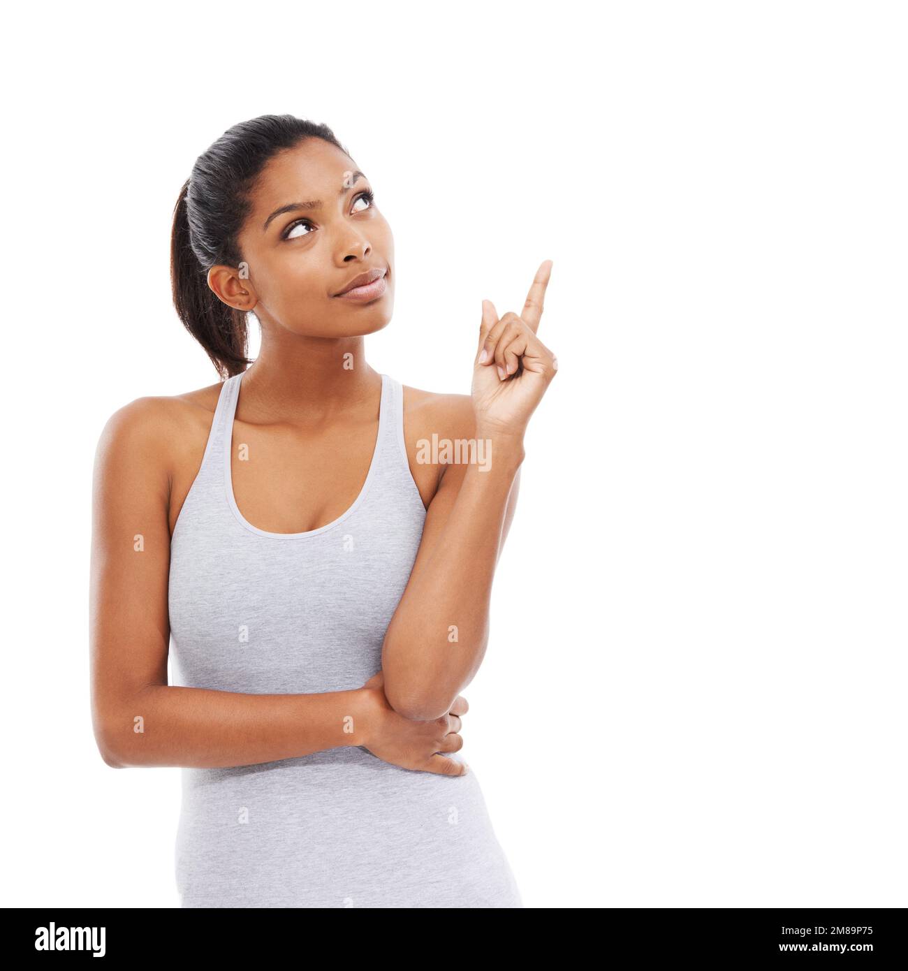 Hier ist die Antwort... Eine junge Frau in Sportkleidung, die nach oben zeigt. Stockfoto