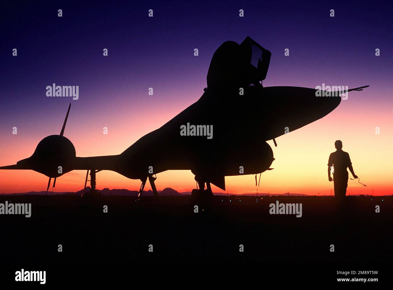Rechte Vorderansicht eines strategischen Aufklärungsflugzeugs der SR-71B Blackbird, das bei Sonnenuntergang auf der Startbahn steht. Der SR-71 ist inoffiziell als „Blackbird“ bekannt. Basis: Luftwaffenstützpunkt Beale Bundesstaat: Kalifornien (CA) Land: Vereinigte Staaten von Amerika (USA) Stockfoto