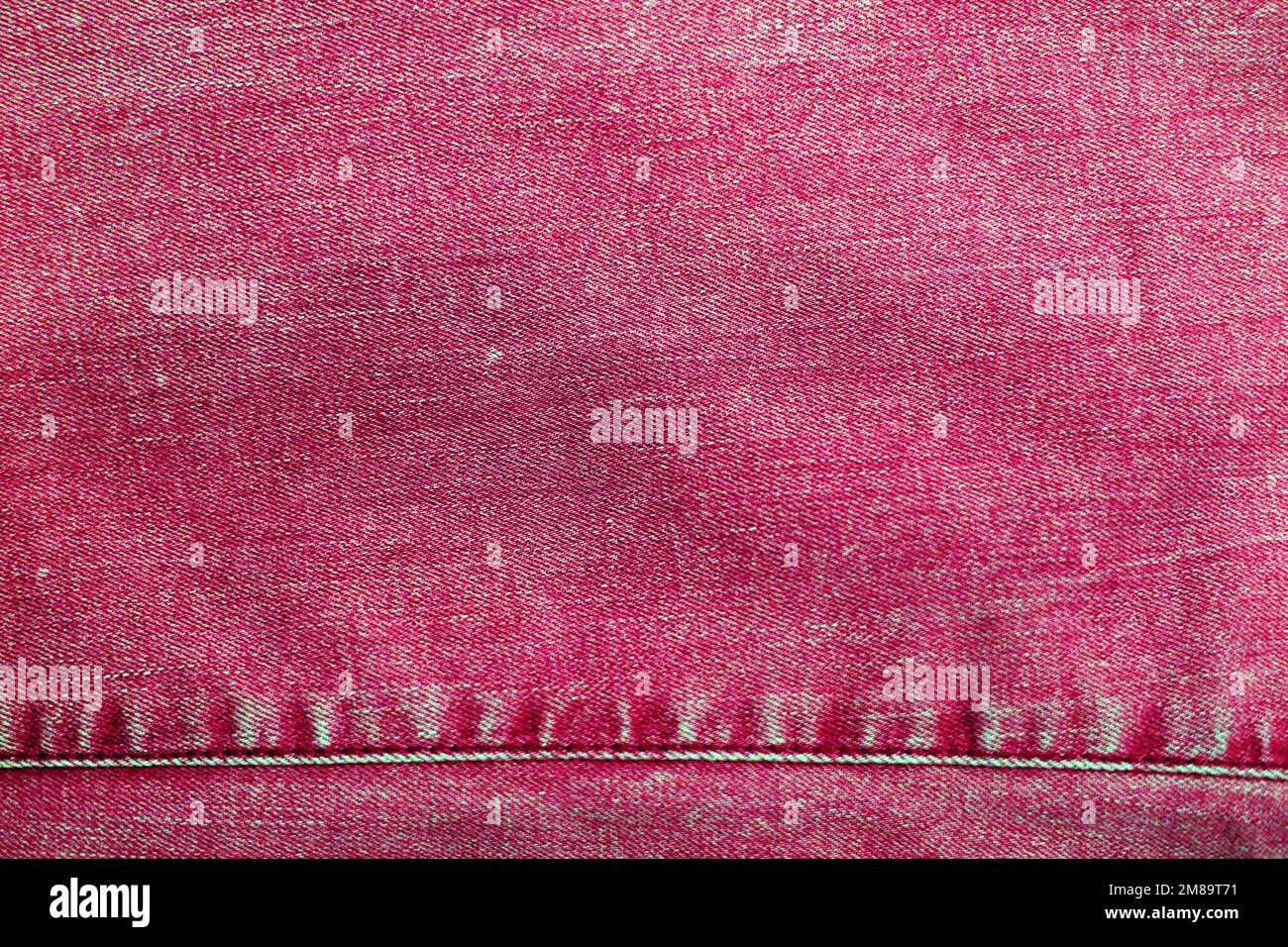 Die Textur von Jeans in Viva magenta Stockfoto