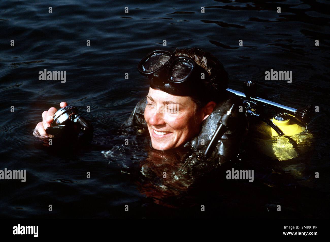 Eine Navy Taucherin taucht auf und überprüft ihr Mundstück. Land: Unbekannt Stockfoto