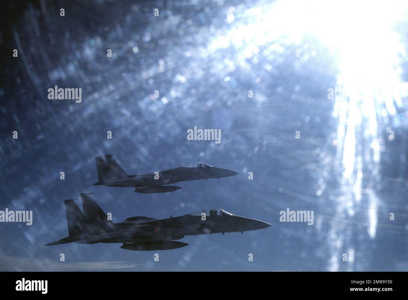 Von hinten beleuchteter Air-to-Air-Blick auf zwei F-15 Eagles, die dem taktischen Kampfflugflügel 49., dem Luftwaffenstützpunkt Holloman, New Mexico, zugewiesen wurden. Das Flugzeug im Vordergrund ist der 7. Taktischen Kampfeinheit zugewiesen. Exaktes Datum Aufnahme Unbekannt. Land: Unbekannt Stockfoto