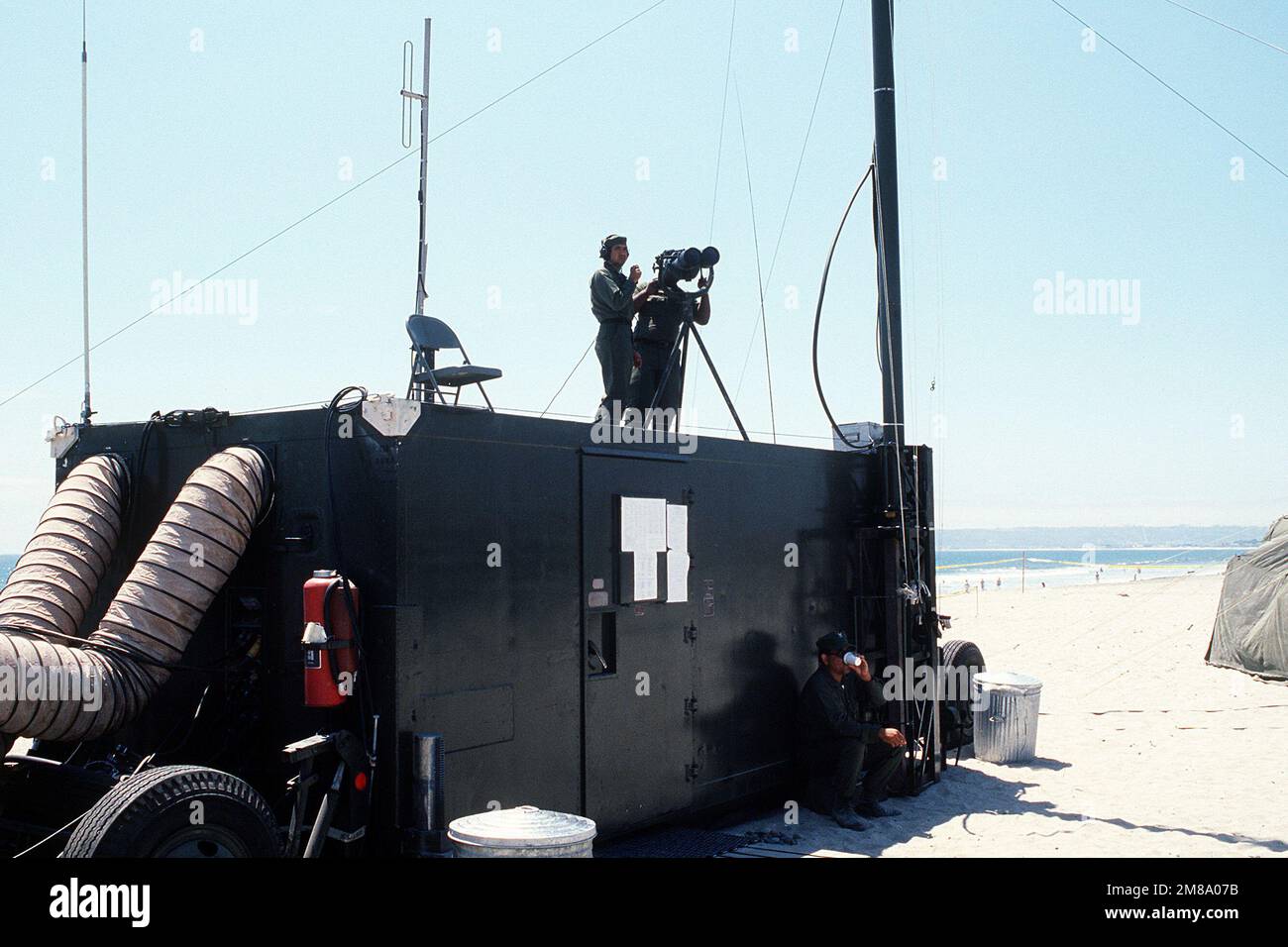 Mitglieder der Mobile Inshore Undersea Warfare (MIUW) Unit 105, USNR, verwenden Ferngläser, um die Aktivität von oben auf einem mobilen Anhänger während der Übung Gallant Eagle '88 zu überwachen. Betreff Operation/Serie: GALLANT EAGLE '88 Basis: San Diego Staat: Kalifornien (CA) Land: Vereinigte Staaten von Amerika (USA) Stockfoto