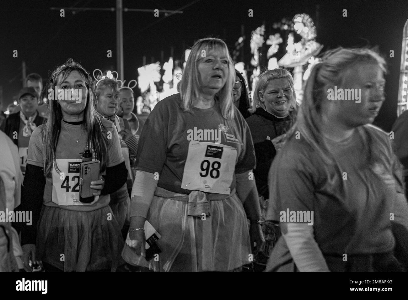 Im Oktober 2022 gehen Frauen durch die Illuminations für den Blackpool Memory Walk, in Unterstützung des Trinity Hospice in Bispham, Lancashire. Stockfoto