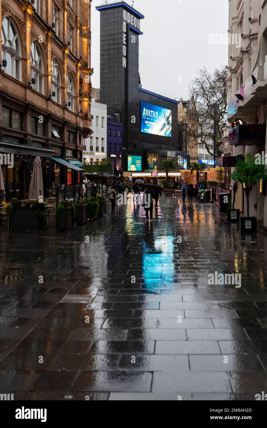 Odeon Cinema Leicester Square, London, Großbritannien, zeigt Avatar, The Way of Water. Nasser und düsterer Winternachmittag. Wet Leicester Place Street mit Geschäften Stockfoto