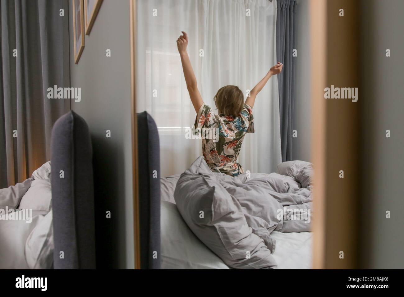 Beweglichkeit des Oberkörpers, wunderschöne junge Frau, die sich nach dem Aufwachen auf dem Bett streckt Stockfoto