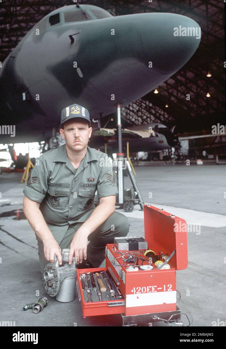 Vor einem Jetstar-Flugzeug der C-140 kniet SSGT Theron Lennon von der 375. Consolidated Aircraft Maintenance Squadron hinter dem Werkzeugkasten, den er für die Reparatur von Kraftstoffsystemen verwendet. Stützpunkt: Luftwaffenstützpunkt Scott Bundesstaat: Illinois (IL) Land: Vereinigte Staaten von Amerika (USA) Stockfoto