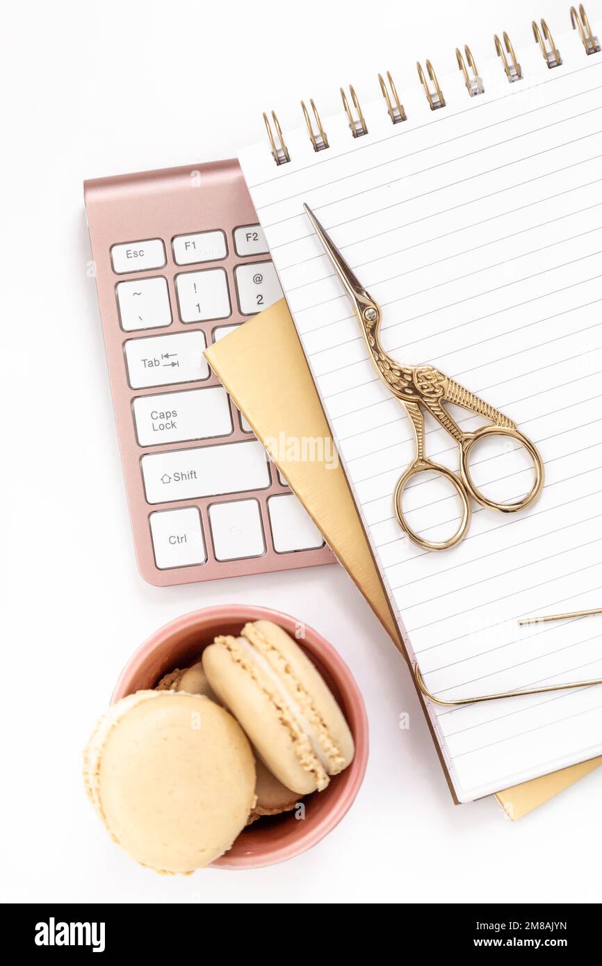 Femininer Schreibtisch mit goldenen und pinkfarbenen Schreibwaren, einschließlich Tastatur und Maus Stockfoto