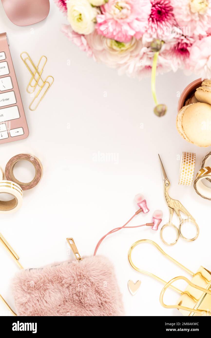 Femininer Schreibtisch mit goldenen und pinkfarbenen Schreibwaren, einschließlich Tastatur und Maus Stockfoto