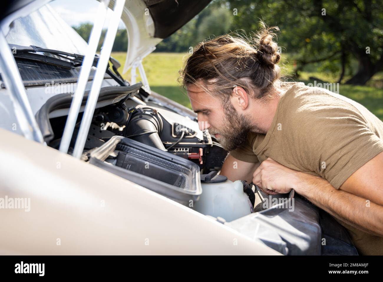 Mann, der im Motorraum eines Lieferwagens im Freien arbeitet Stockfoto