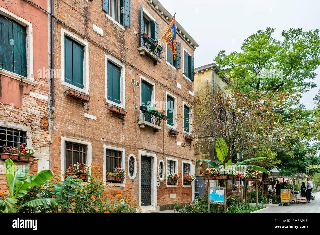 Eine malerische Straße namens „Rio Terà dei Pensieri“ mit venezianischer Flagge, Pflanzen und Vegetation im viertel Dorsoduro, Stadtzentrum von Venedig, Italien Stockfoto