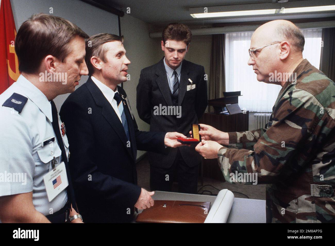 OBERST Richard Myers, richtig, kommandierender Offizier, 38. Taktischer Raketenflügel, stellt dem sowjetischen Inspektionsteam-Führer Vladmir Tselischev eine Nadel als MASTER SGT vor. Thomas Klobucar, Left, ein Mitglied des Inspektionsteams vor Ort, und der sowjetische Übersetzer Miroslav Ufimtsev schauen. Die Sowjets führten eine Inspektion am Stützpunkt durch, um die Einhaltung des INF-Abkommens (Intermediate-Range Nuclear Forces) durch die USA sicherzustellen. Basis: Luftwaffenstützpunkt Wueschheim Land: Bundesrepublik Deutschland (BRD) Stockfoto