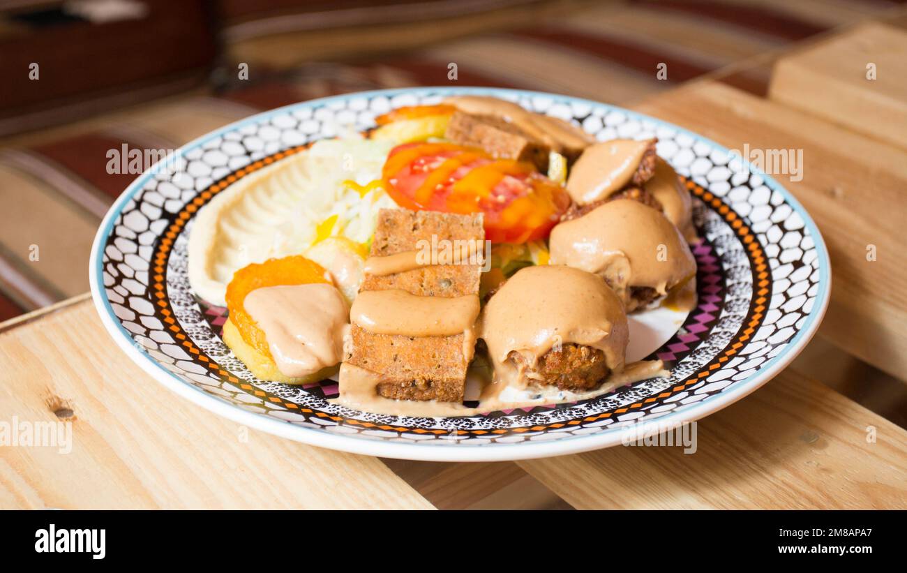 Falafel-Kombi-Gericht mit Gemüse. Faláfel oder falafel​ ist eine Kichererbse oder Bohnenkrokette. Es wird normalerweise im Nahen Osten konsumiert. Stockfoto
