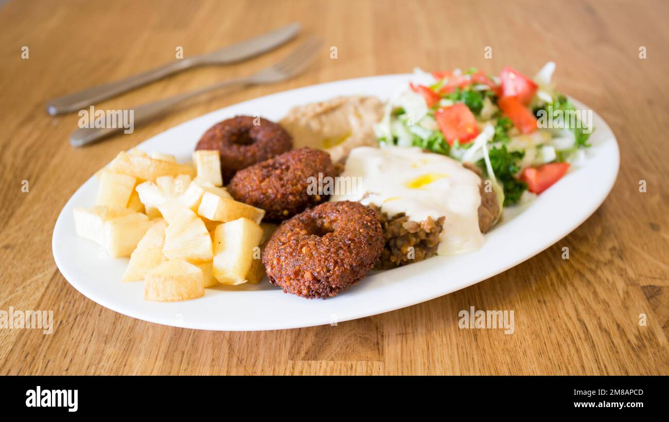 Falafel-Kombi-Gericht mit Gemüse. Faláfel oder falafel​ ist eine Kichererbse oder Bohnenkrokette. Es wird normalerweise im Nahen Osten konsumiert. Stockfoto