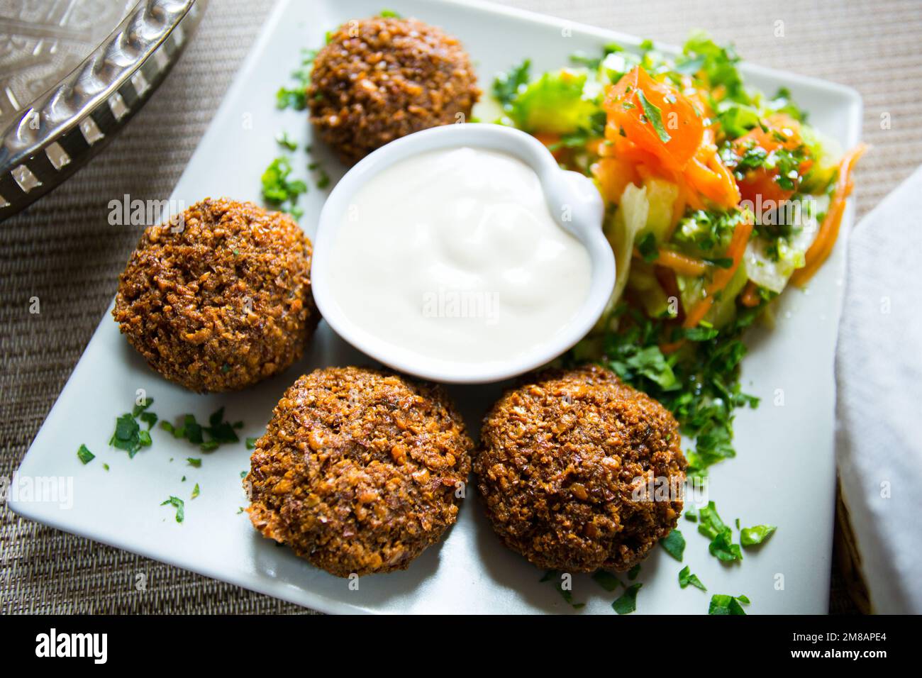 Falafel-Kombi-Gericht mit Gemüse. Faláfel oder falafel​ ist eine Kichererbse oder Bohnenkrokette. Es wird normalerweise im Nahen Osten konsumiert. Stockfoto
