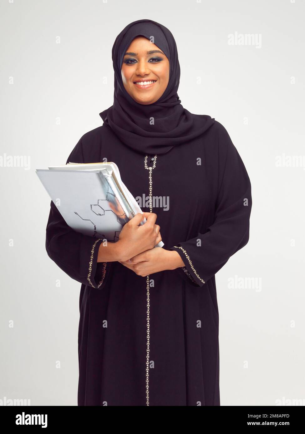 Porträt, islam und Bücher mit einer Studentin im Studio auf grauem Hintergrund zum Lernen oder zur Bildung. Muslim, Universität und Studium mit einem islamisten Stockfoto