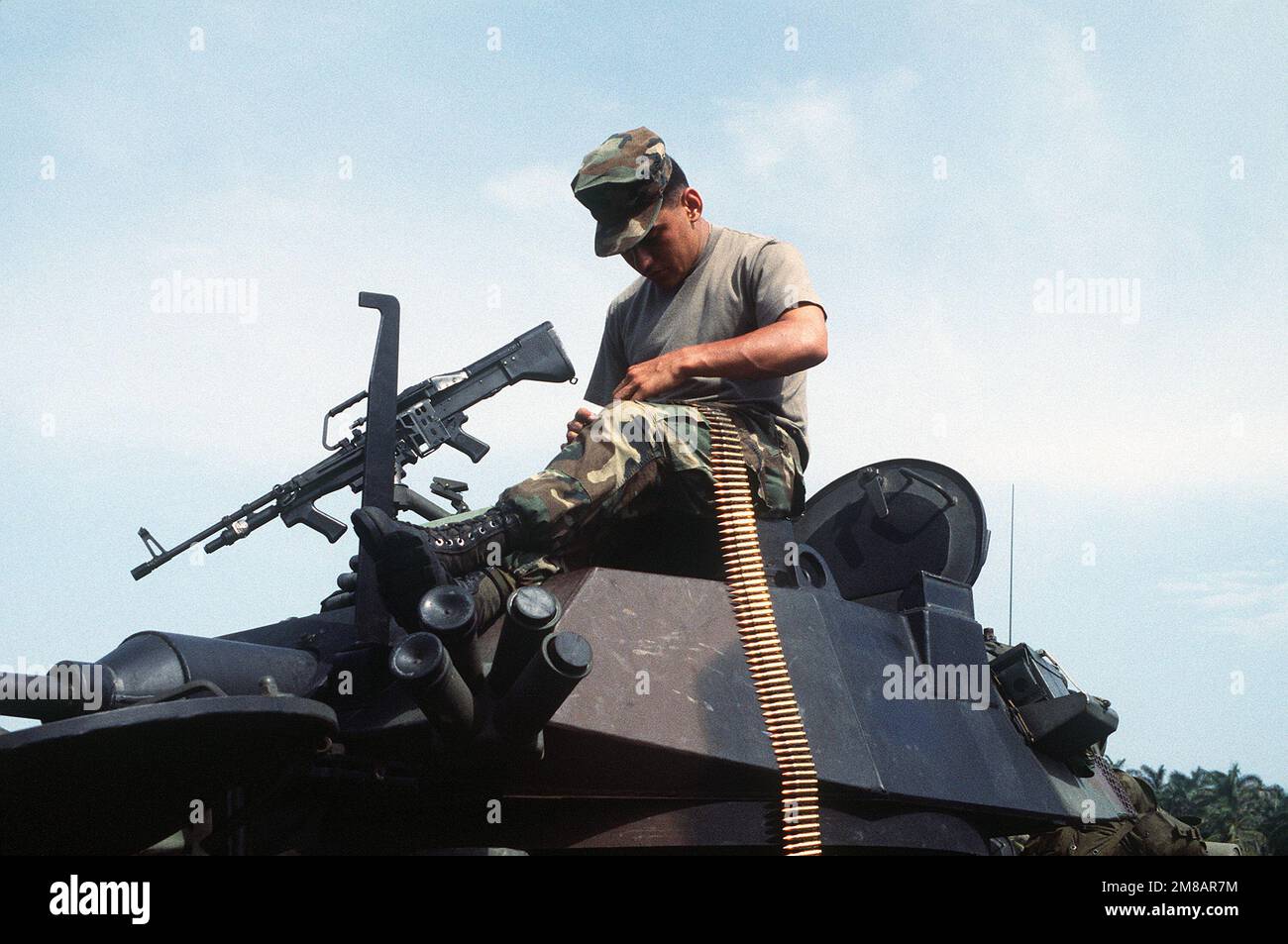 Ein Marine sitzt auf einem LAV-25 Light Armored Vehicle (LAV), während er Gürtel mit 7,62mm-Munition für das Maschinengewehr M-60 des Fahrzeugs zusammenhängt. Land: Panama (PAN) Stockfoto