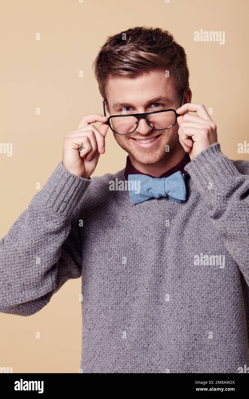 Schick für Geek. Studioporträt eines stilvoll gekleideten jungen Mannes, der eine Brille trägt und in die Kamera lächelt. Stockfoto