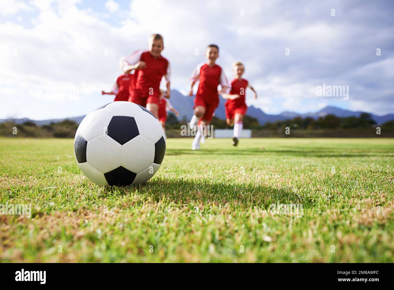 Der Ball ist da, um gewonnen zu werden. Ein Kinderfußballteam auf dem Platz. Stockfoto