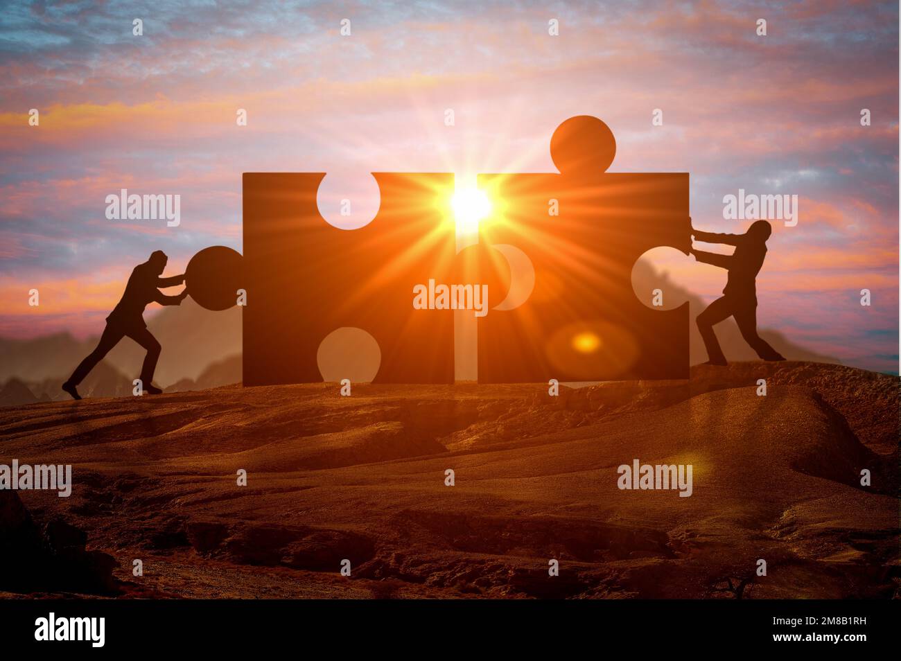 Teamarbeit, Partnerschaft und Zusammenarbeit. Teamwork- und Integrationskonzept. Silhouetten von zwei Geschäftsleuten, die zwei Puzzleteile miteinander verbinden. Verbinden Stockfoto