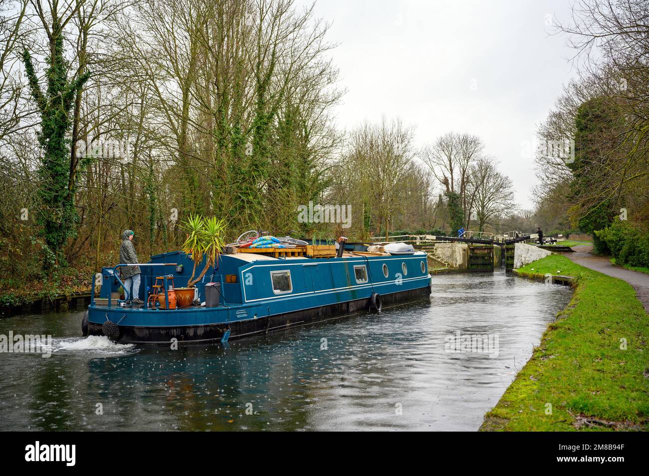 Hanwell Locks am Grand Union Canal in Hanwell, Greater London, Großbritannien. Ein Kanalboot, das im Regen durch Schleuse Nummer 96 fährt. Stockfoto