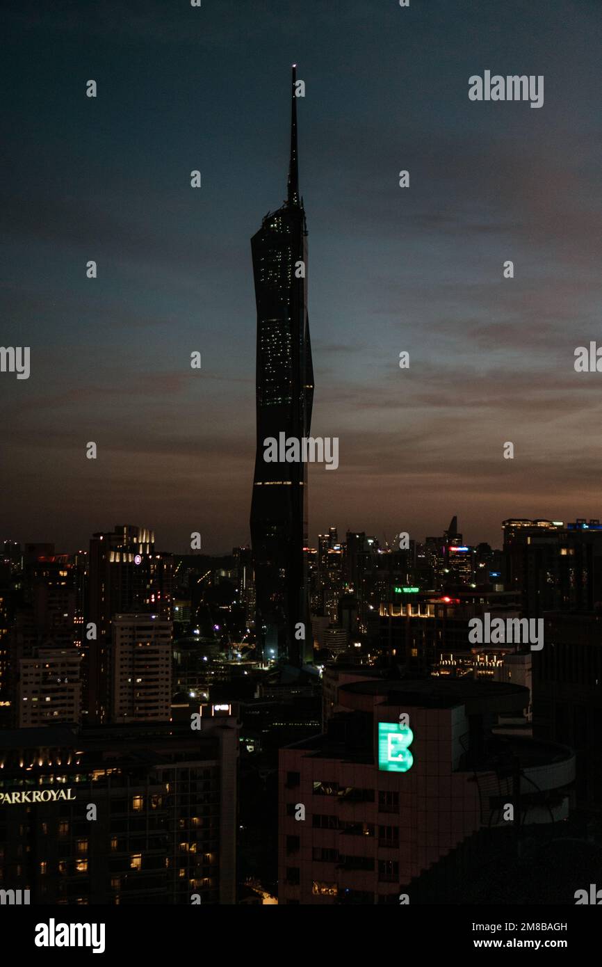 Eine vertikale Aufnahme der Silhouette des Warisan Merdeka Tower in Kuala Lumpur während des Sonnenuntergangs Stockfoto