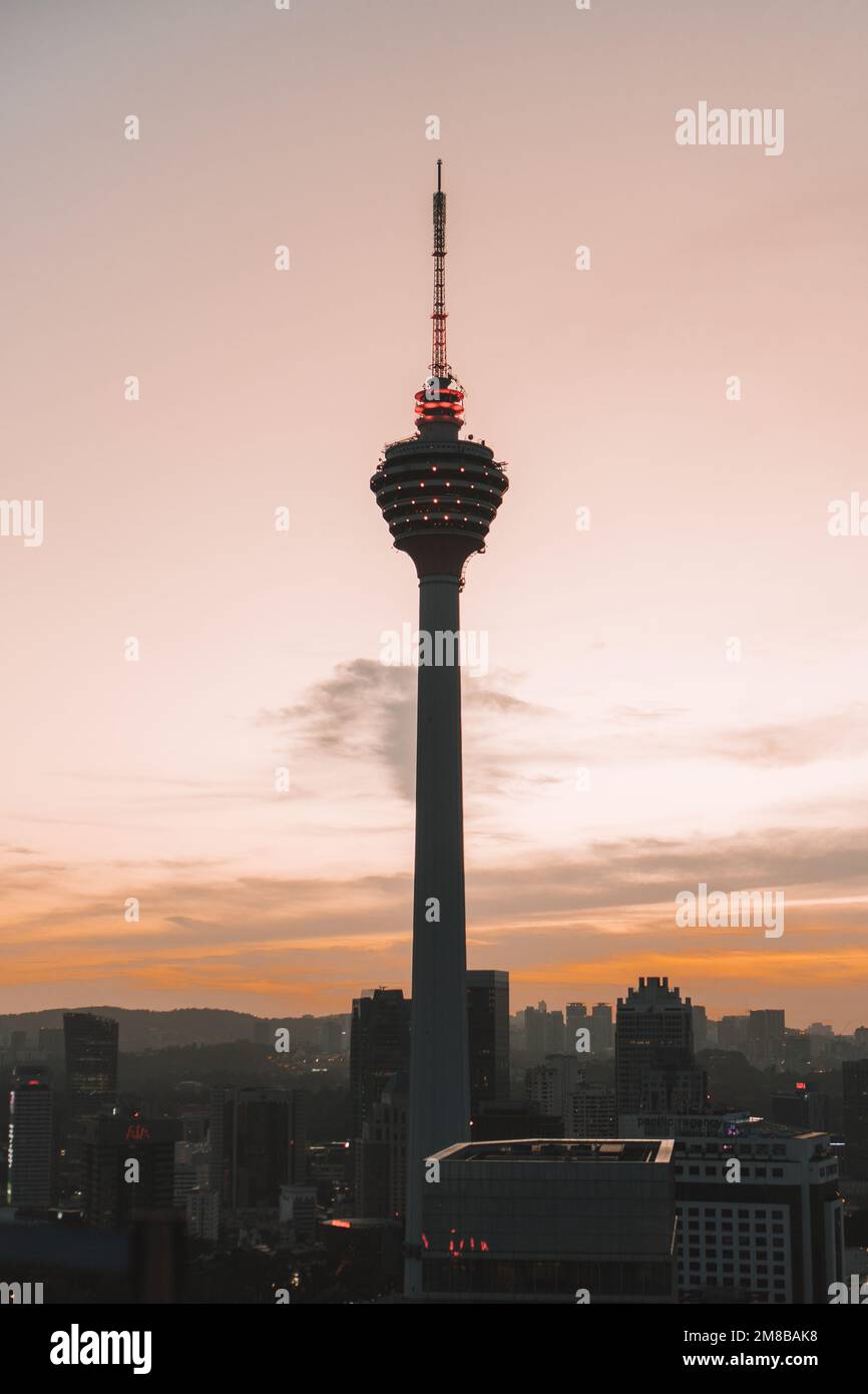 Eine vertikale Aufnahme der Silhouette des Menara Tower in Kuala Lumpur während des Sonnenuntergangs Stockfoto