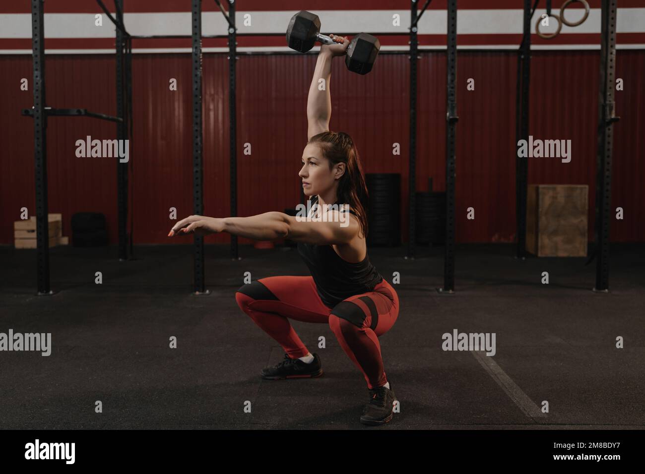 Starke Sportlerin, die Kurzhanteln-Squats macht. CrossFit Sportlerinnen  Gewichte tragen. Praktisches Training Stockfotografie - Alamy