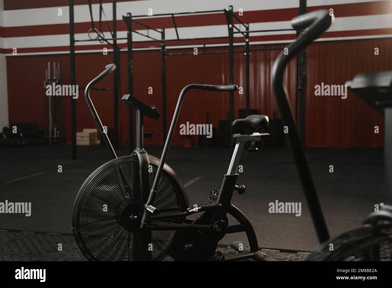 Trainingsräder für Cardio-Training in rotem Crossfit-Fitnessstudio. Airbikes im Fitnessraum Stockfoto