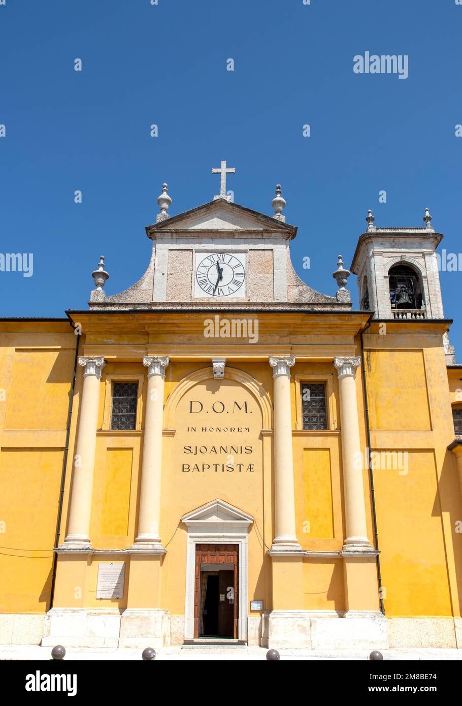 Eine Vertikale der Fassade der Cavaion Kirche mit einer Uhr und einem Kreuz unter dem blauen Himmel Stockfoto
