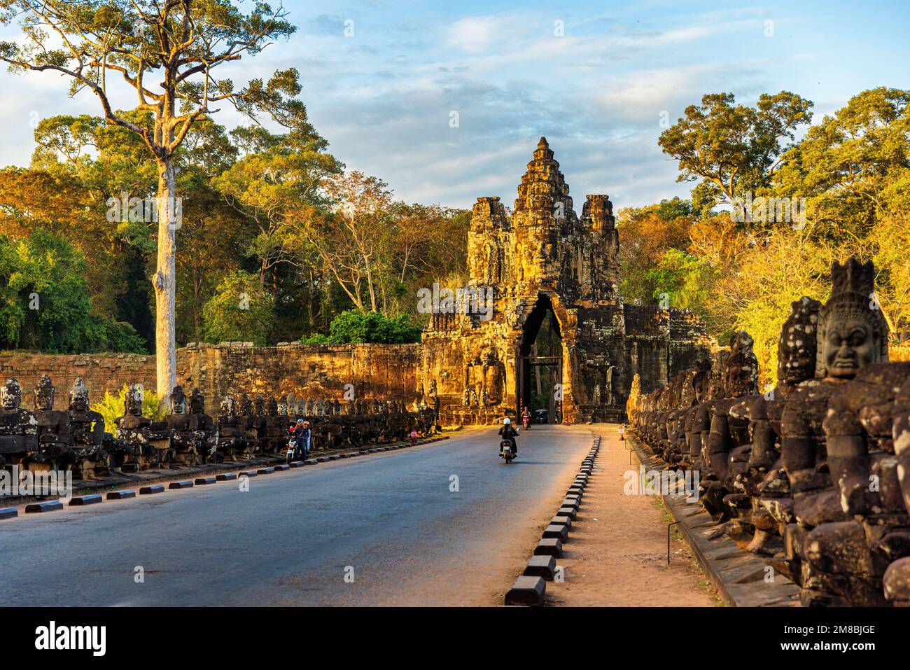 SIEM REAP, 11. JANUAR 2023: Motorräder auf der Brücke zum Südtor von Angkor Thom, Kambodscha Stockfoto
