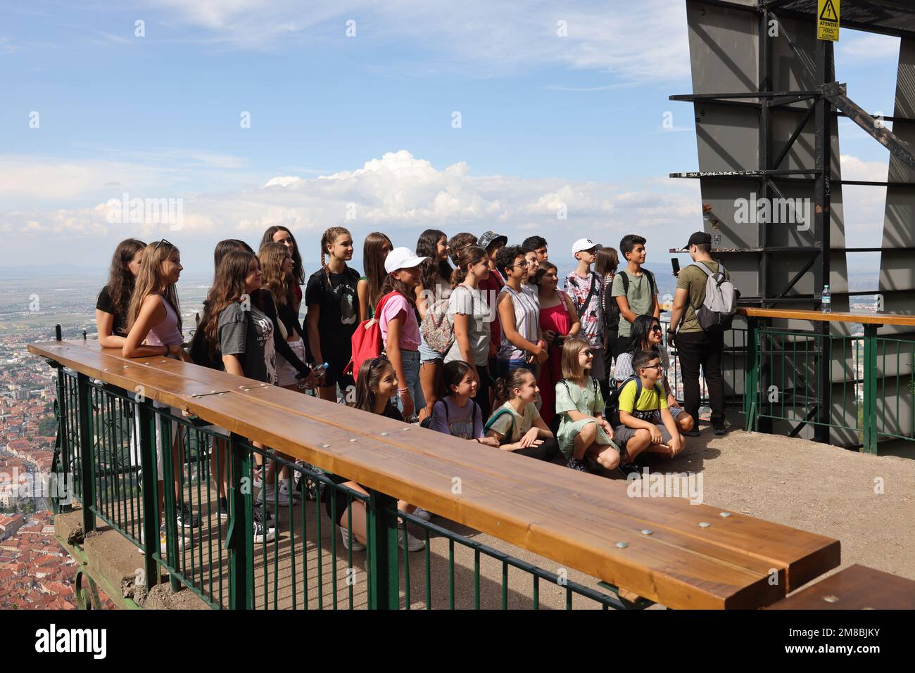 Gruppe von Jugendlichen (vielleicht eine Schulklasse?) Posieren Sie für ein Foto auf einer Panoramaplattform (auf dem Gipfel des Mount Tampa in Rumänien, neben dem Brașov-Schild) Stockfoto