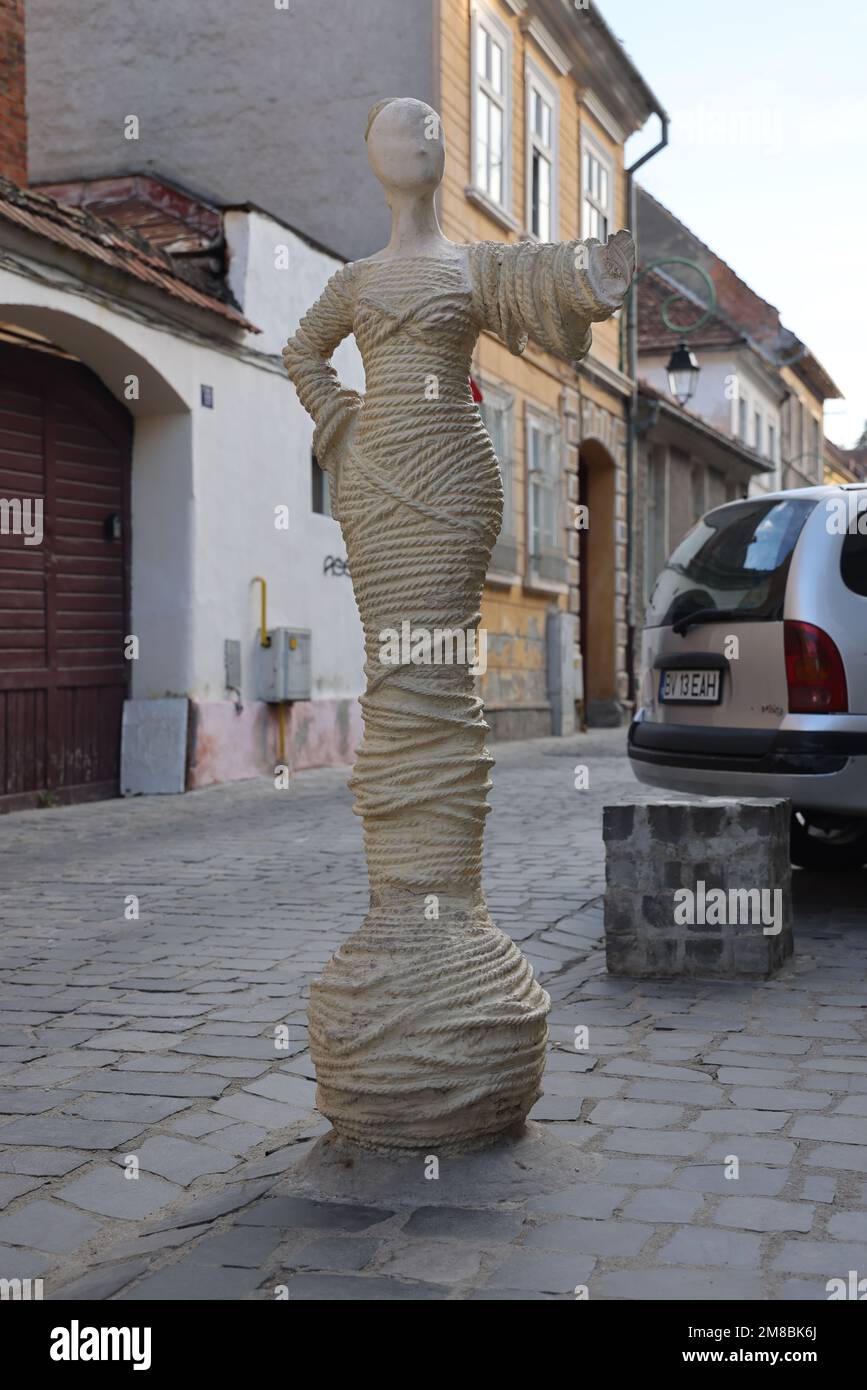 Statue einer Dame bedeckt mit Seilen am Eingang zur Strada Sforii (Seilstraße). Die schmalste Straße von Brașov Rumänien; eine der schmalsten in Europa Stockfoto