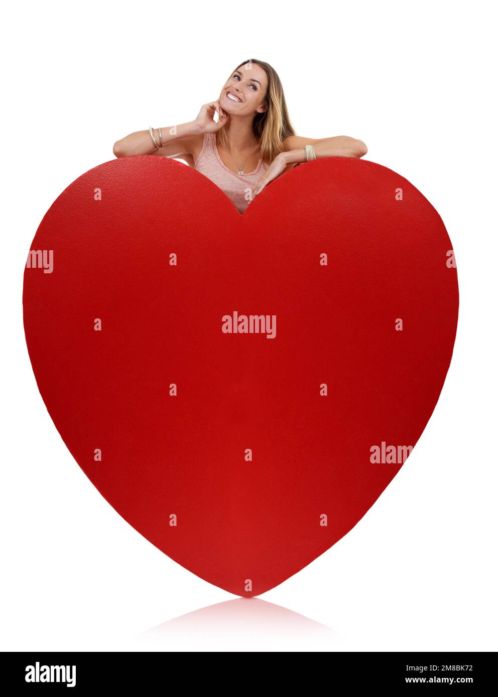 Herz, verliebt und Frau, glücklich mit Freiheit und lustiges aufgeregtes Gefühl hinter dem Schild. Model, weißer Hintergrund und komischer junger Mensch mit Glück, Freude Stockfoto