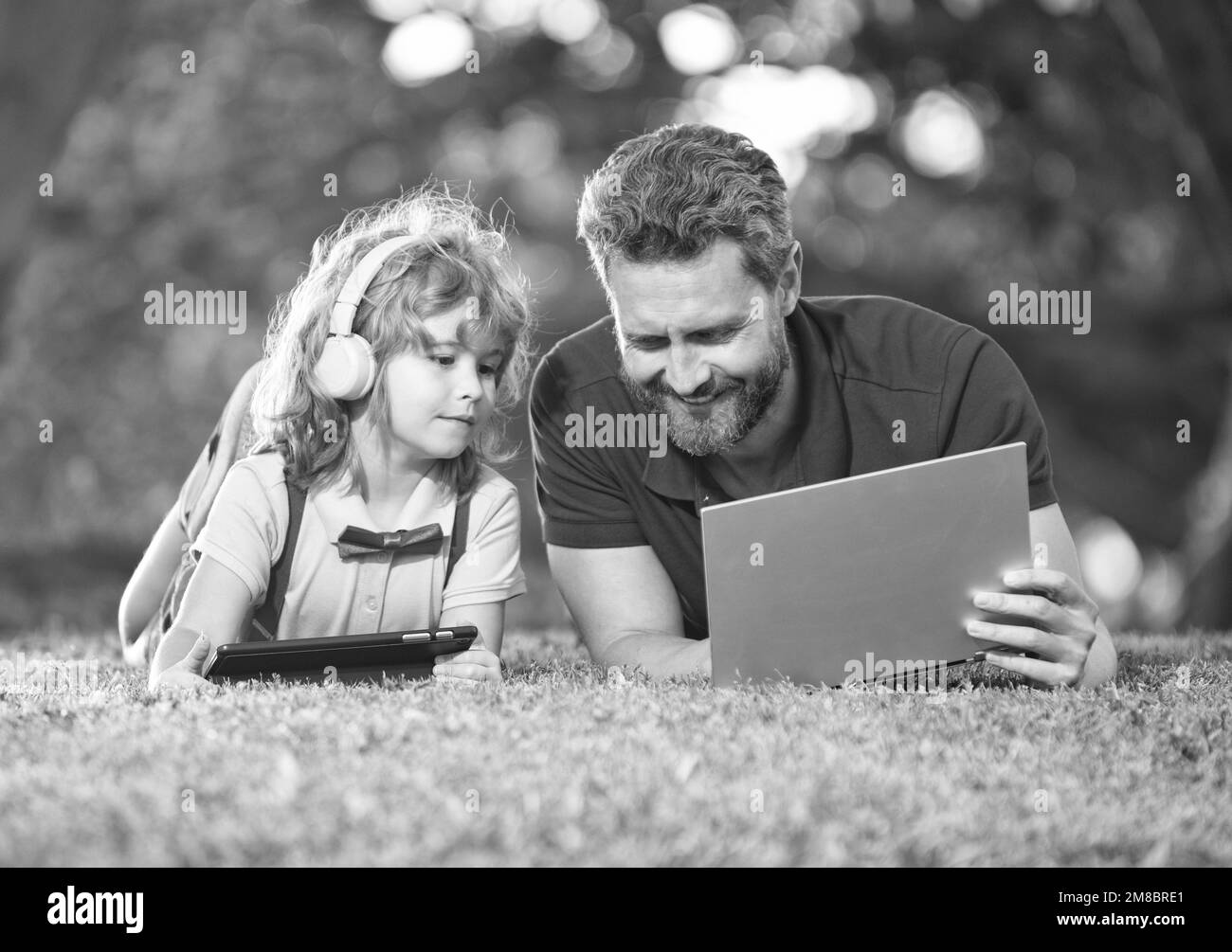 Glückliche Familie von Vater und Sohn im Park, drahtlose Technologie. Stockfoto