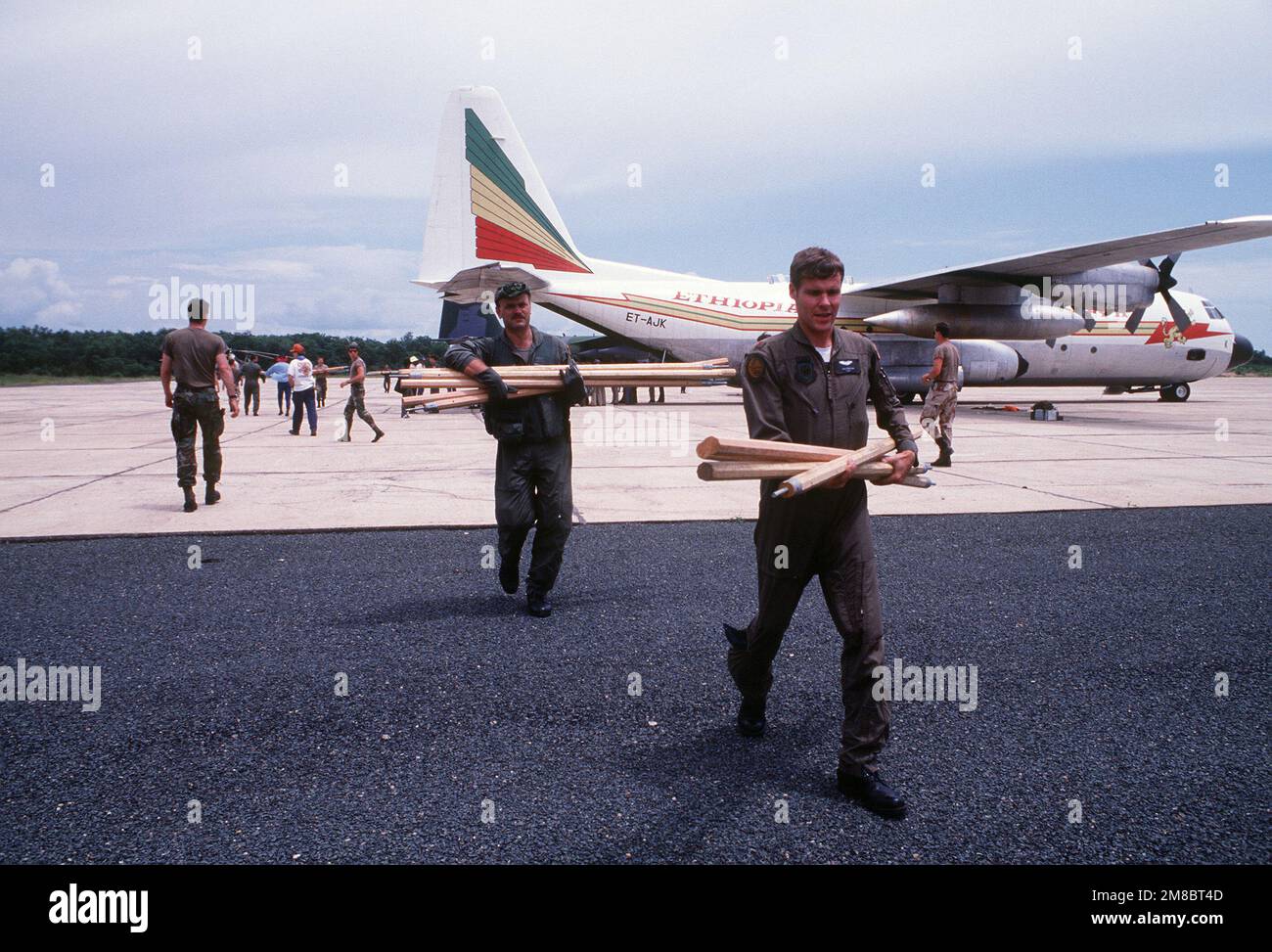 Mitglieder des Rettungsteams entladen Zeltstangen aus einem äthiopischen C-130-Herkules-Flugzeug am Gambela South Airport, Einsatzzentrum für Truppen, die eingetroffen sind, um die Leichen von Texas Rep. George T. (Mickey) Leland und Mitgliedern seiner Delegation zu Bergen. Eine Suche wurde eingeleitet, nachdem das Flugzeug, das Leland und 15 weitere Personen transportierte, auf dem Weg zu einem Flüchtlingslager in der Nähe der sudanesischen Grenze als vermisst gemeldet wurde. Die Bemühungen führten zur Entdeckung des abgestürzten Flugzeugs an einem abgelegenen Berghang. Land: Äthiopien (ETH) Stockfoto