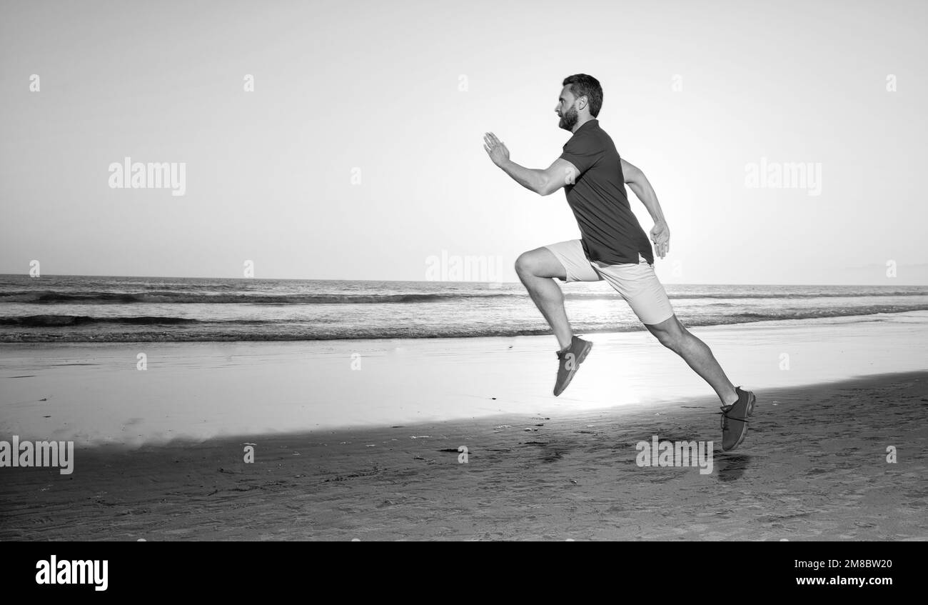 Sportlicher Mann Jogger Joggen am Sonnenuntergang Sommerstrand am Meer, Copy Space, Joggen Stockfoto