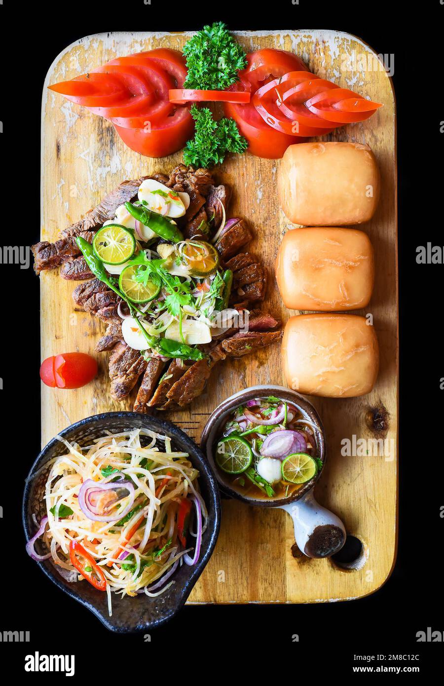 Gegrilltes thailändisches Rindfleisch mit Papayasalat, vietnamesischen Brötchen und Kumquat-Sauce mit Blick von oben Stockfoto