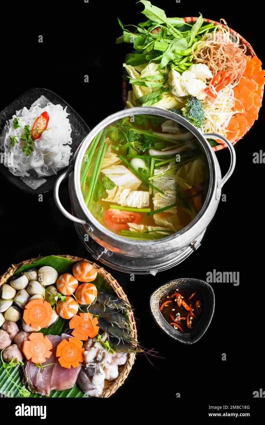 Koreanischer Hot Pot mit Meeresfrüchten und Nudeln auf schwarzem Hintergrund Stockfoto