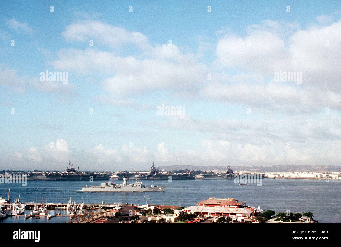 Die Fregatte USS WHIPPLE (FF 1062) fährt an den Trägerpiers der Naval Air Station auf North Island vorbei, da sie zu Beginn des PACEX '89 aus San Diego ablegt. Im Hintergrund sind die Flugzeugträger USS CONSTELLATION (CV 64), Left, USS RANGER (CV 61), Center und USS INDEPENDENCE (CV 62), Right gebunden. Betreff Betrieb/Serie: PACEX '89 Basis: San Diego Staat: Kalifornien (CA) Land: Vereinigte Staaten von Amerika (USA) Stockfoto