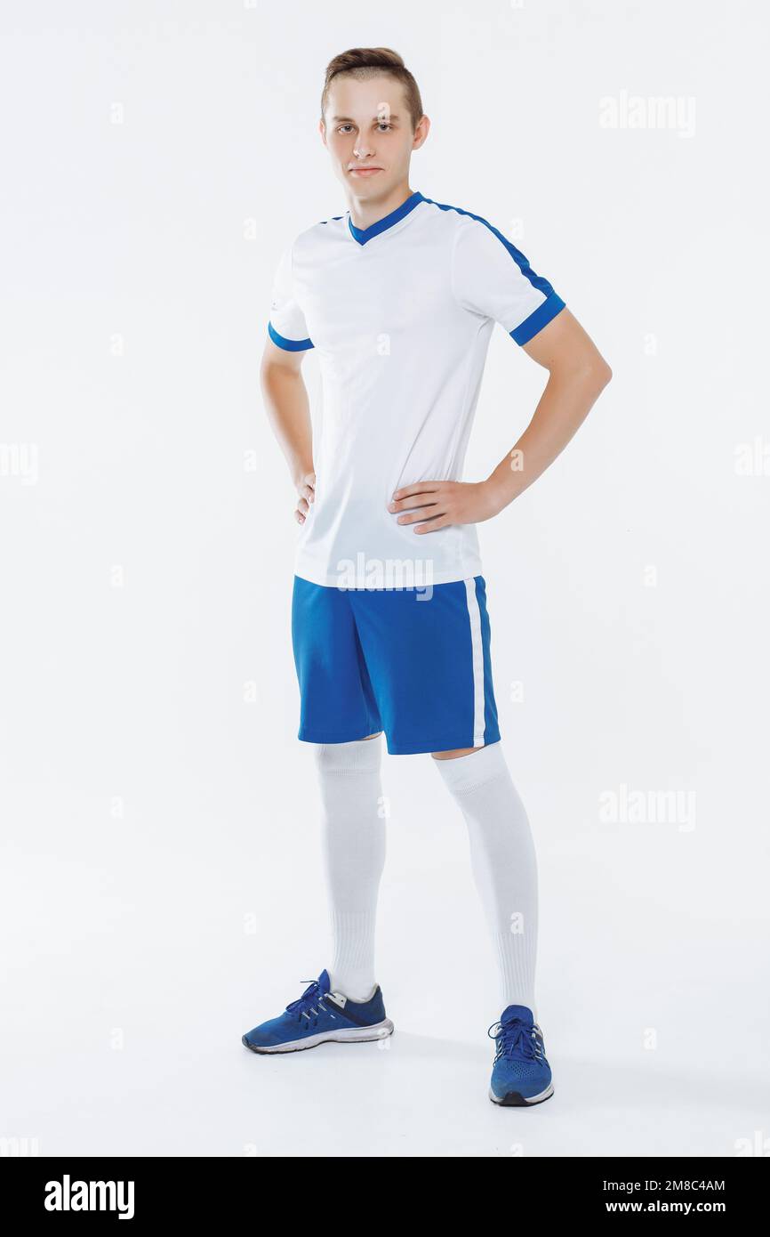Fußballspieler in weiß-blauer Uniform vor weißem Hintergrund Stockfoto