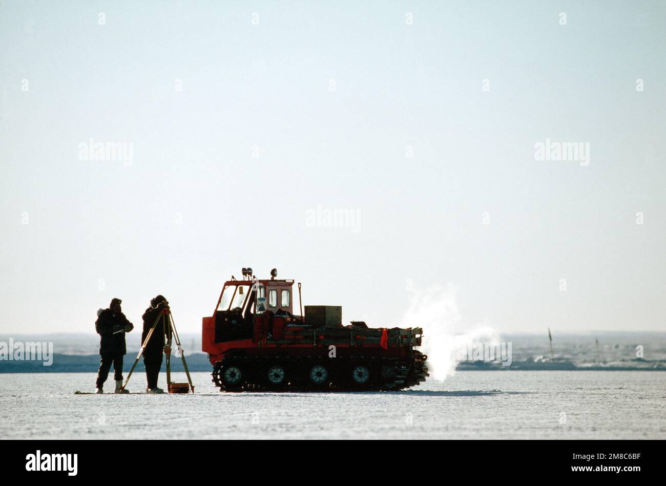 Ausrüster Baulehrling Leon Williams und Ausrüster 1. Klasse Ray Poulin ermitteln mit einem Messgerät die Auswirkungen des Gewichts eines C-5B Galaxy-Flugzeugs auf die Eisschicht, auf der es geparkt war. Die C-5B ist in der McMurdo Station während der Operation TIEFKÜHLTRUHE '90. Betrifft Operation/Serie: TIEFKÜHL '90 Land: Antarktis (ATA) Stockfoto
