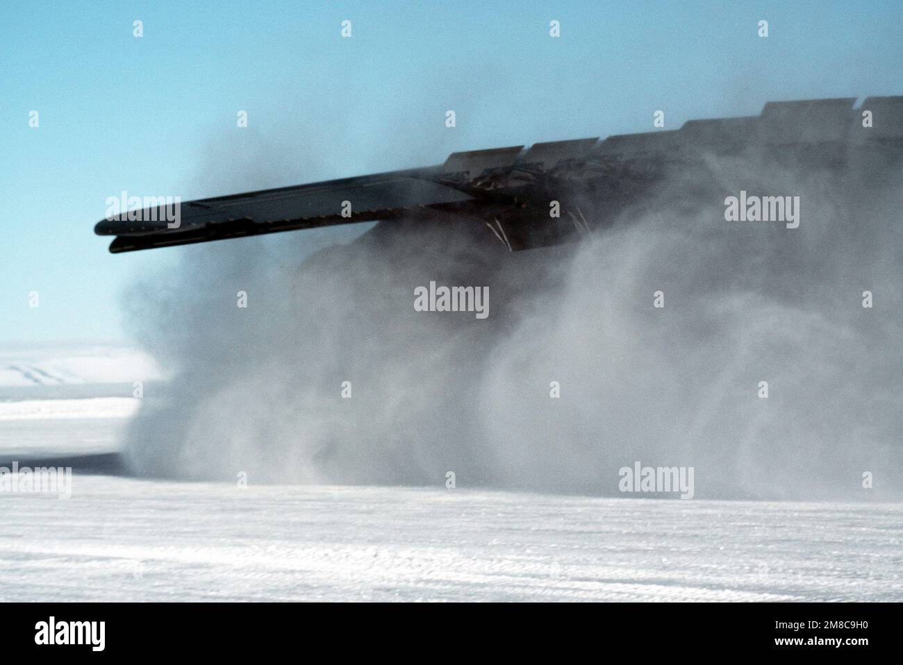 Eine Wolke von Eispartikeln umhüllt den Flügel eines C-5B-Galaxy-Flugzeugs, das auf der Eislaufbahn in der Nähe der McMurdo-Station landet, während DER OPERATION DEEP FREEZE '90. Die Galaxie ist das zweite Flugzeug dieser Art, das auf der über 10.000 Meter langen Landebahn landet, die über 1,80 Meter tief aus dem Eis gekratzt wurde. Betrifft Operation/Serie: TIEFKÜHL '90 Land: Antarktis (ATA) Stockfoto