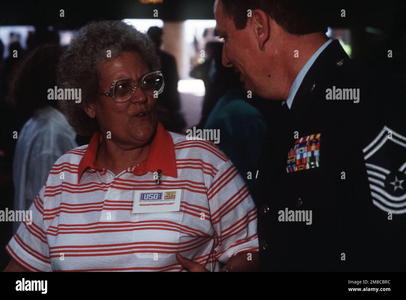CMSGT Ellis Barton begrüßt Irene Gobble bei ihrer Ankunft am Los Angeles International Airport nach ihrer Reise zum Misawa Air Base, Japan. Gobble war einer von 230 Angehörigen des Militärpersonals, die in Japan stationierte Angehörige besuchten und später ihre Rückreise in die Vereinigten Staaten an Bord des von dem ehemaligen Präsidenten Ronald Reagan gecharterten Boeing 747-Flugzeugs unternahmen. Reagan und seine Frau Nancy begleiteten die Reisenden. Basis: Los Angeles Bundesstaat: Kalifornien (CA) Land: Vereinigte Staaten von Amerika (USA) Stockfoto