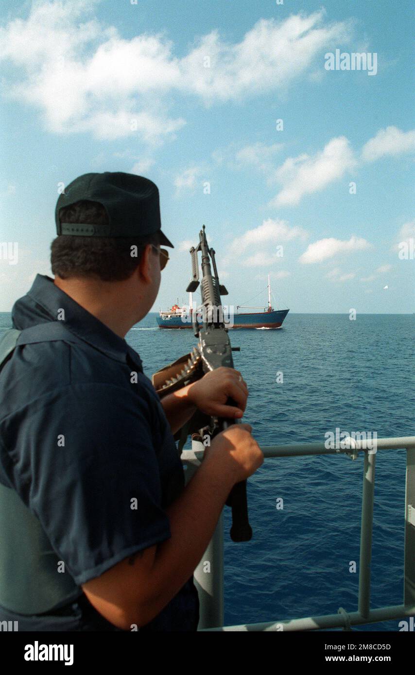 Ein Matrose, der ein M-60-Maschinengewehr an Bord des Tragflügels USS TAURUS (PHM-3) besetzt, beobachtet ein kleines Handelsschiff, das nach einer abrupten Kursänderung gestoppt wurde. Die TAURUS und die anderen Tragflächenboote der PHM-Staffel 2 patrouillieren im Rahmen des nationalen Drogenverbots durch die Gewässer um Florida. Land: Golf Von Mexiko Stockfoto