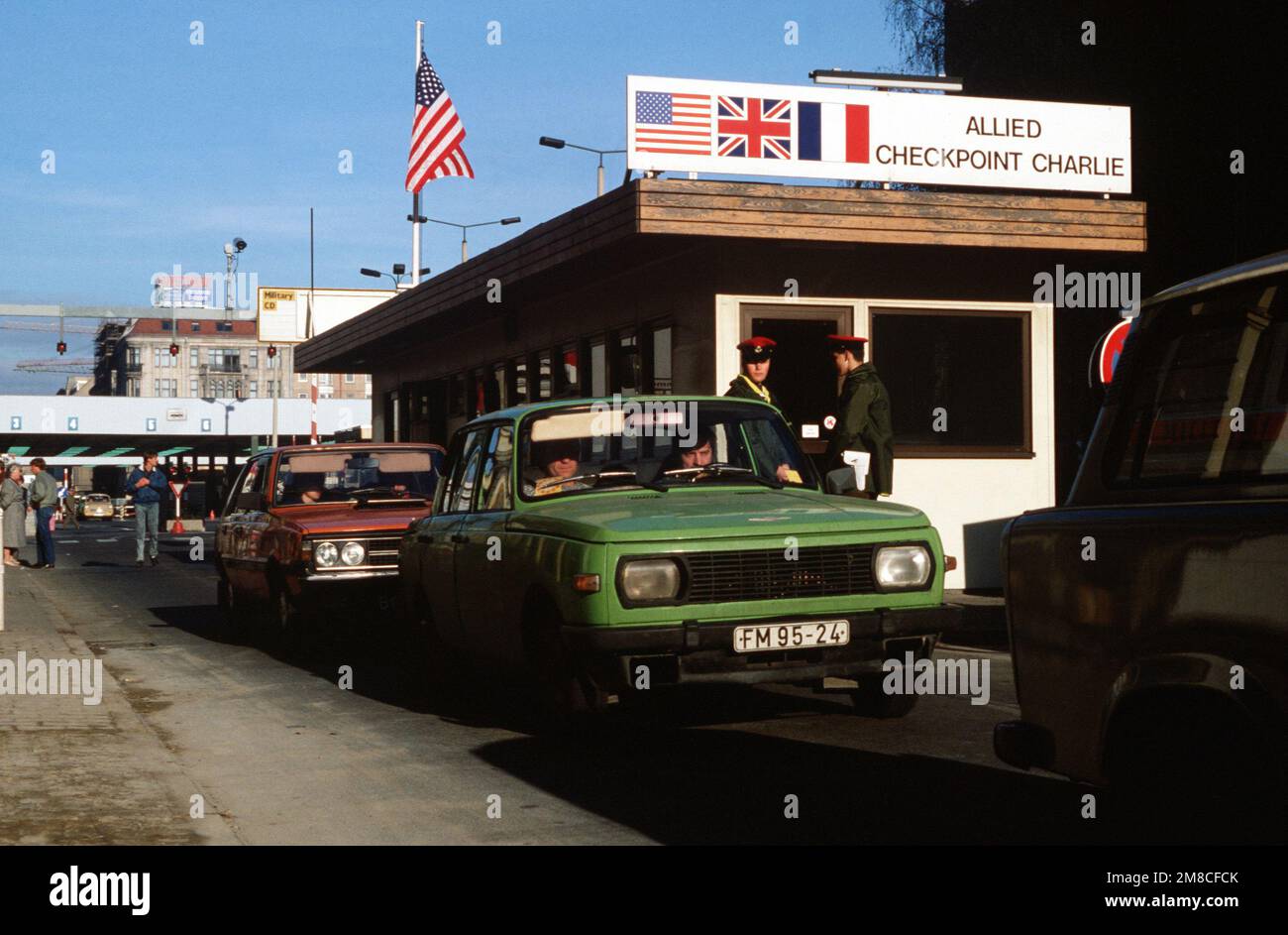 Ostdeutscher fahren mit ihrem Auto durch Checkpoint Charlie und nutzen die lockeren Reisebeschränkungen für einen Besuch in Westdeutschland. Basis: Berlin Land: Deutschland / Deutschland (DEU) Stockfoto