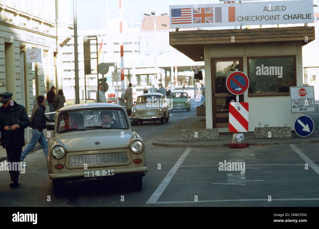 Ostdeutscher fahren mit ihrem Auto durch Checkpoint Charlie und nutzen die lockeren Reisebeschränkungen für einen Besuch in Westdeutschland. Basis: Berlin Land: Deutschland / Deutschland (DEU) Stockfoto