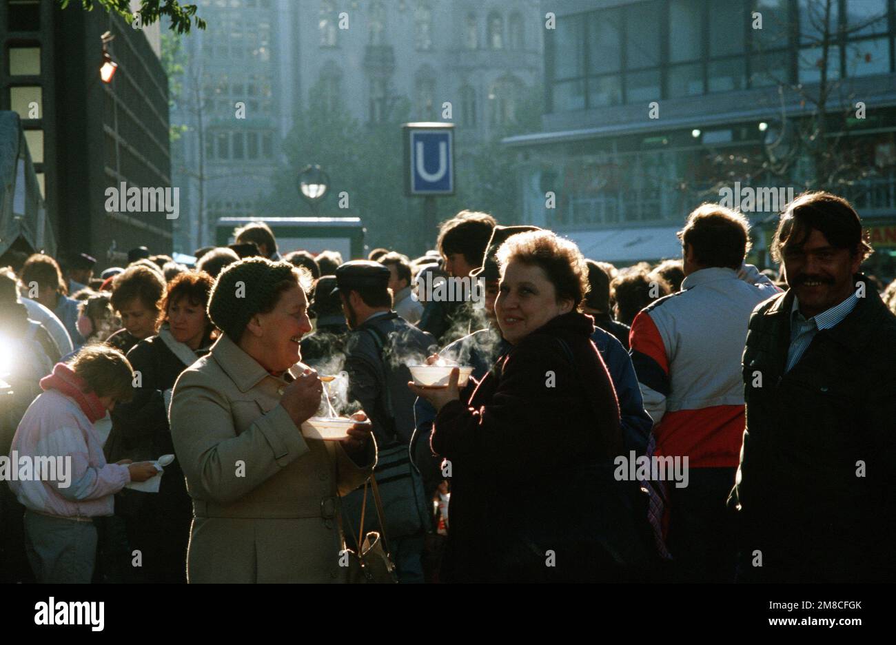 Ostdeutsche Besucher genießen eine warme Suppe am Ku'damm in Westberlin. Das Rote Kreuz versorgt die Ostdeutschen, die nach dem Abriss von Teilen der Berliner Mauer den Westen besuchen, mit kostenlosen Speisen. Basis: Berlin Land: Deutschland / Deutschland (DEU) Stockfoto