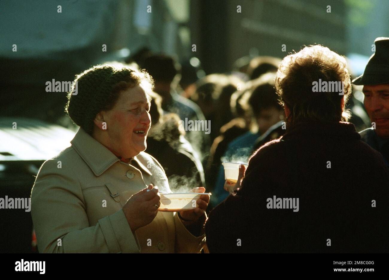 Ostdeutsche Besucher genießen eine warme Suppe am Ku'damm in Westberlin. Das Rote Kreuz versorgt die Ostdeutschen, die nach dem Abriss von Teilen der Berliner Mauer den Westen besuchen, mit kostenlosen Speisen. Basis: Berlin Land: Deutschland / Deutschland (DEU) Stockfoto